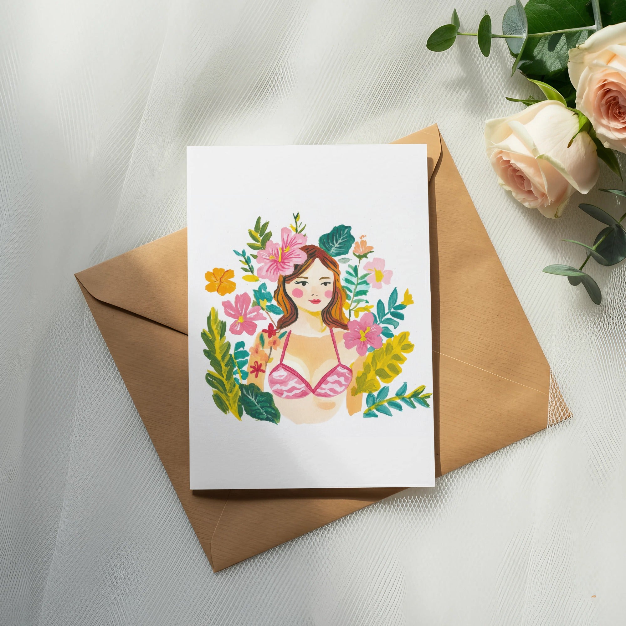 Watercolor illustration of a woman's face with flowers and foliage, on a card atop an envelope.