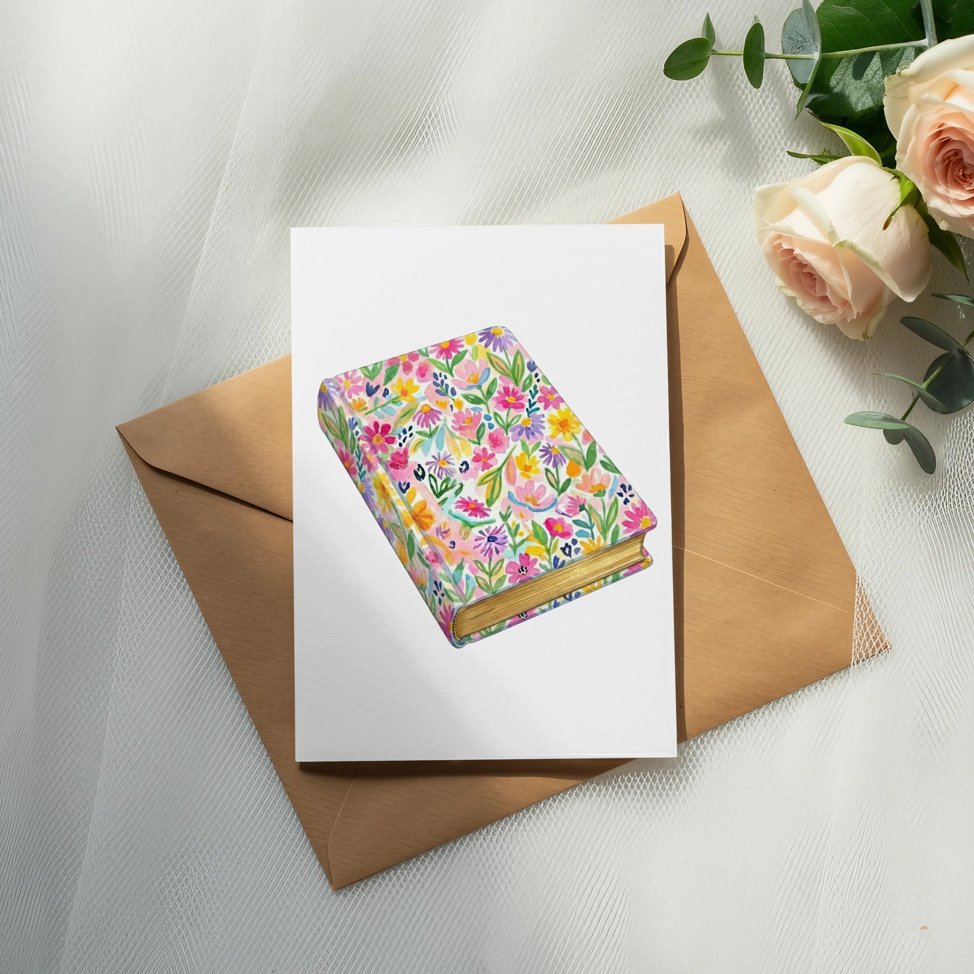 Watercolor illustration of a book with a floral cover on an envelope.