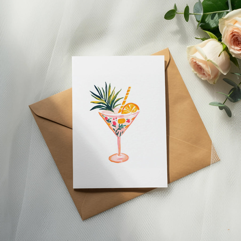 Watercolor cocktail in a patterned glass with straw and fruit garnish.