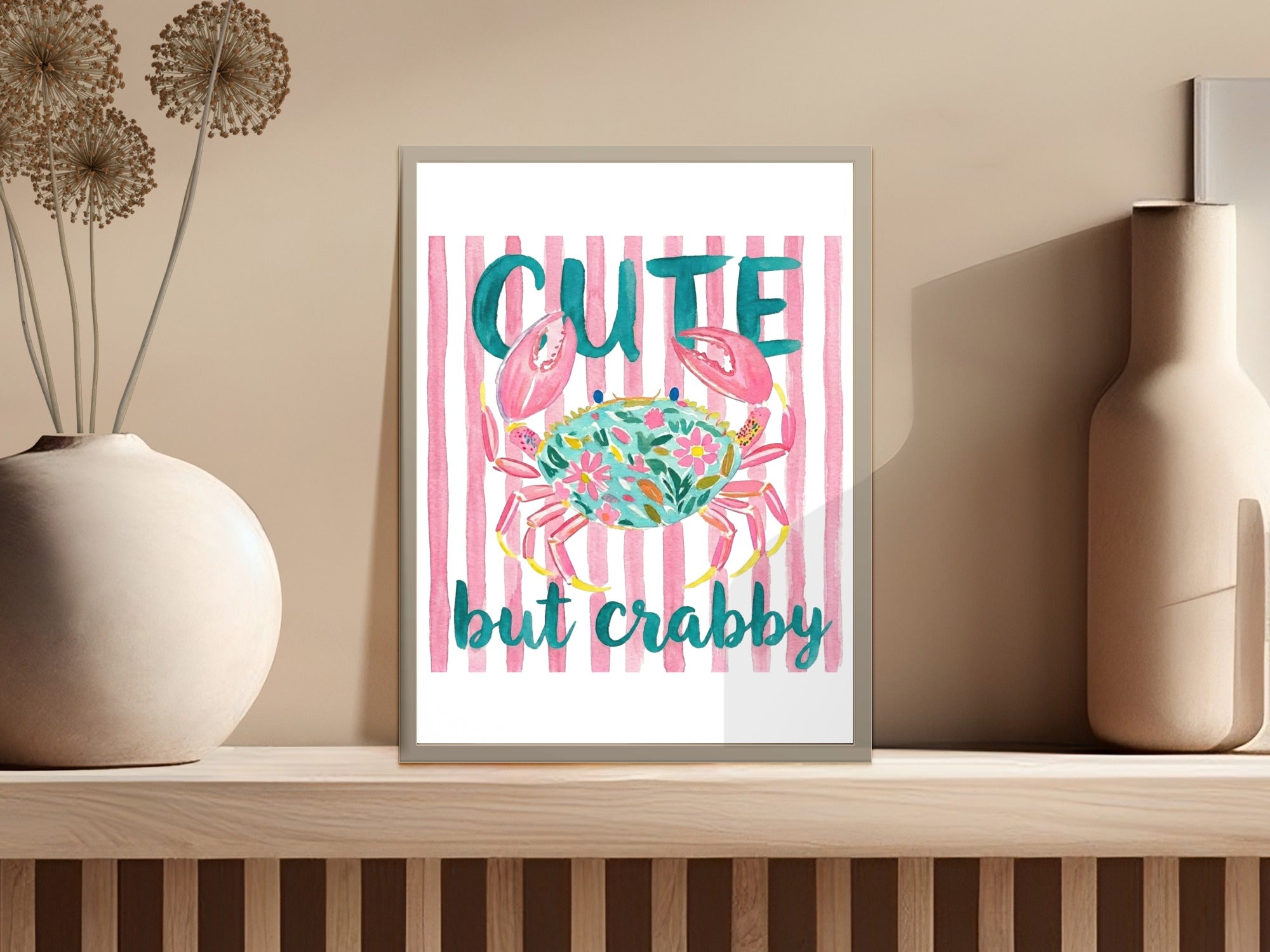 Watercolor crab with "cute but crabby" text on pink stripes.