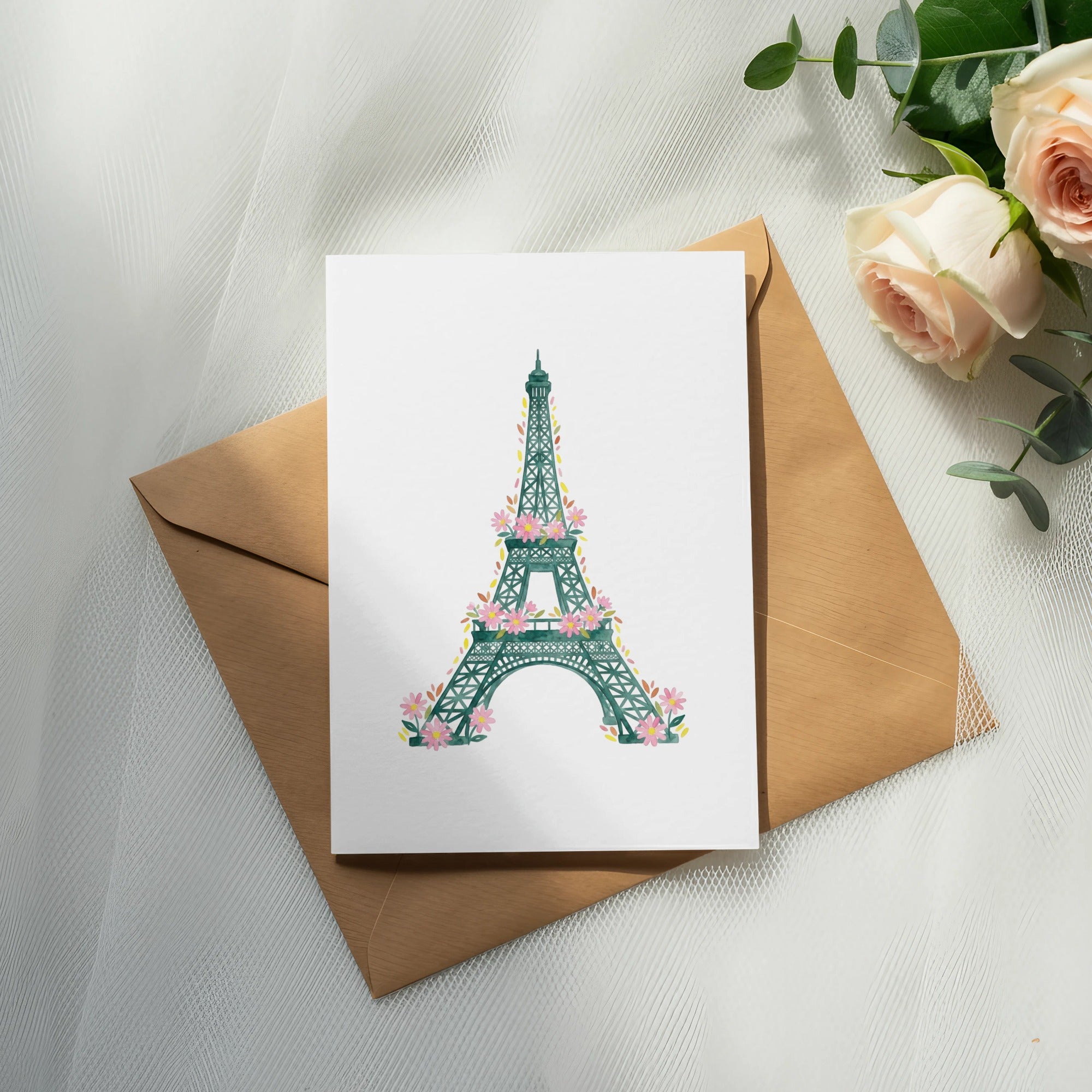 Eiffel Tower illustration with pink flowers on a card atop a brown envelope.