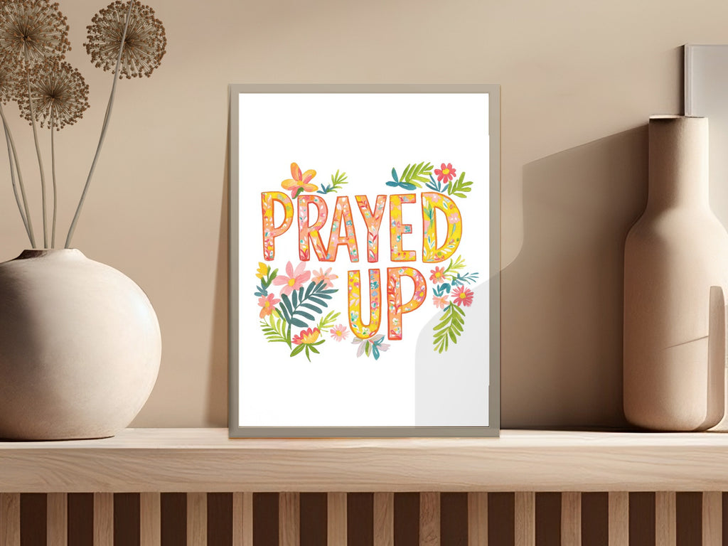 PRAYED UP typography art with floral accents in a framed display.