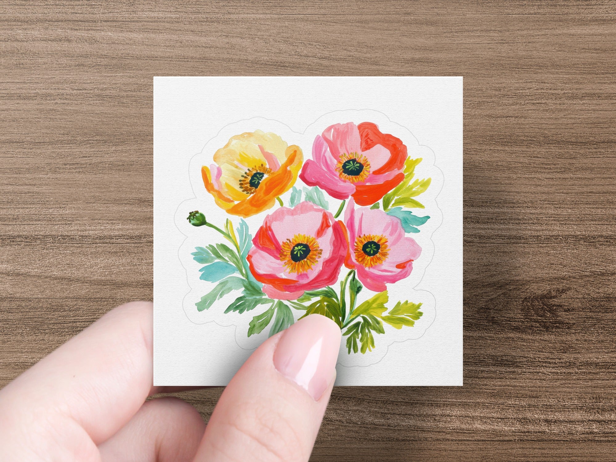 Hand holding sticker featuring a bouquet of four vibrant poppies and green leaves.