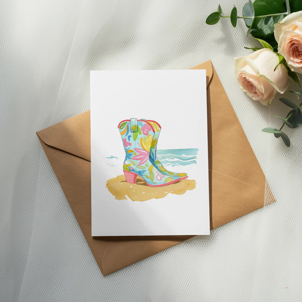 Watercolor cowboy boot with floral pattern on a beach scene, on an envelope.