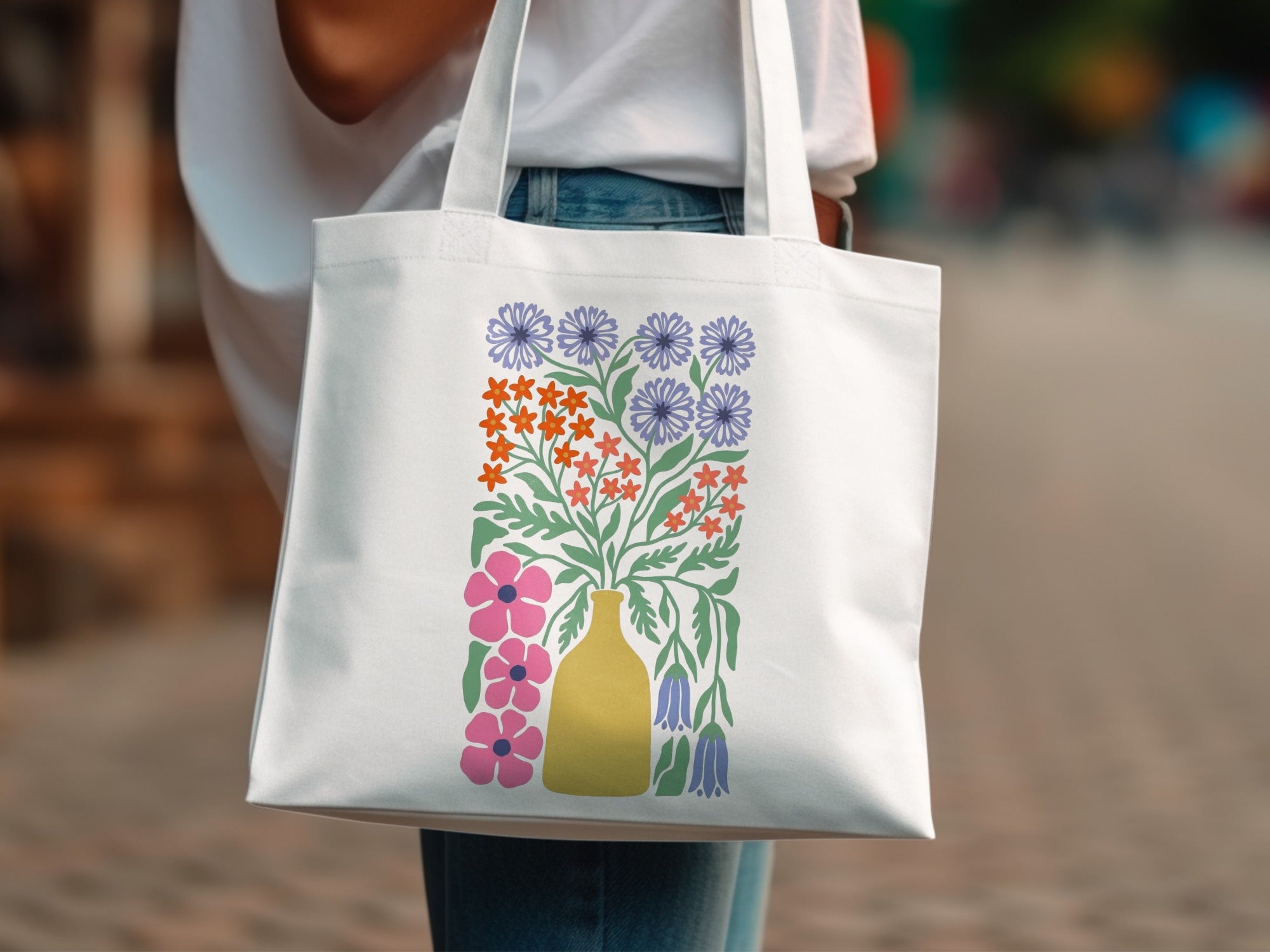 White tote bag with a colorful floral bouquet design in a yellow vase.