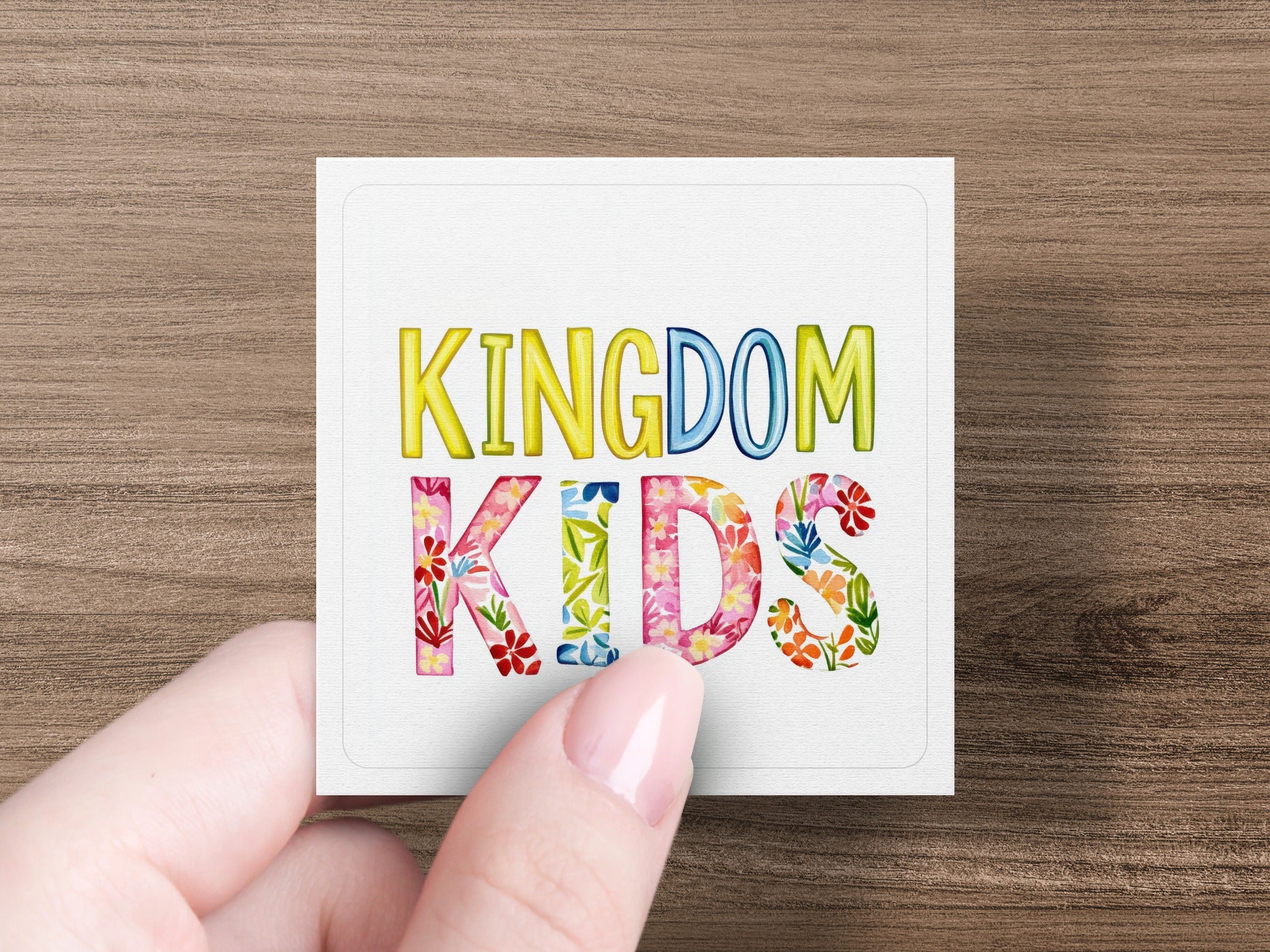 White square with "KINGDOM KIDS" text, letters filled with colorful flowers.