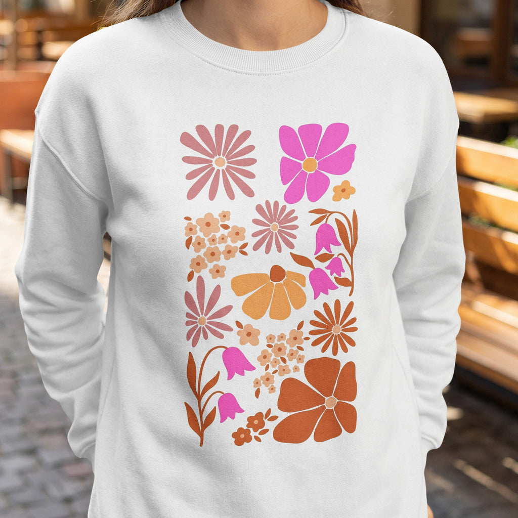 Crewneck sweatshirt with a collage of retro-style floral illustrations in pink, orange, and brown.