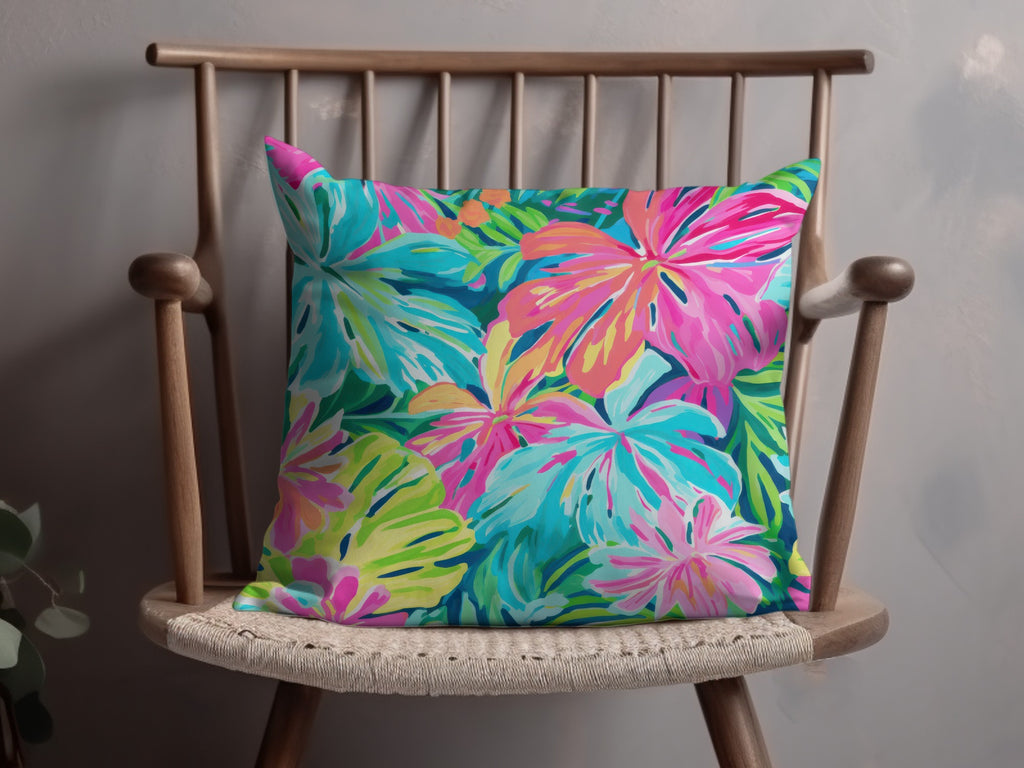 Pillow with a vibrant tropical floral pattern on a wooden chair.