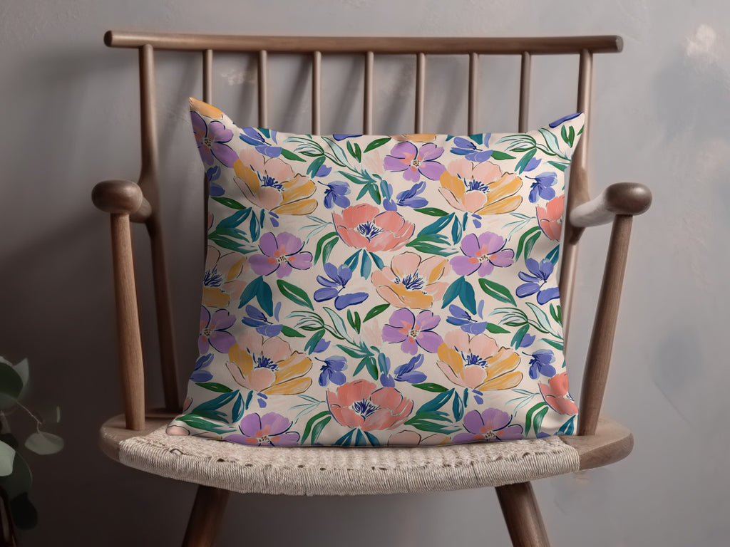 Floral patterned throw pillow on a wooden chair.