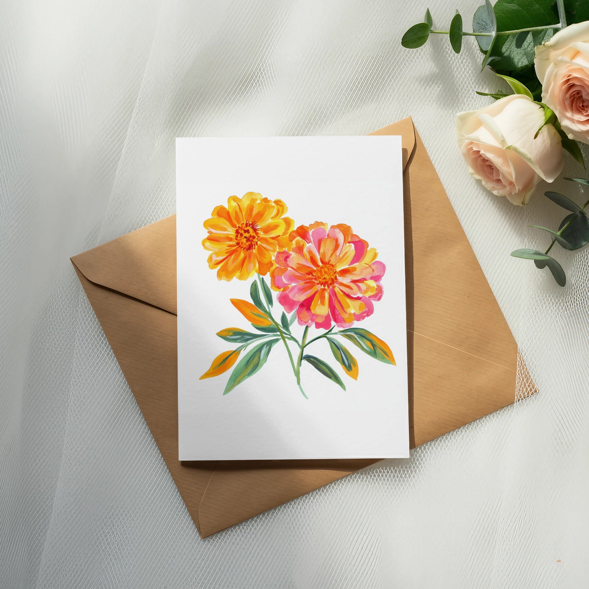 Watercolor flowers on card over brown envelope with roses and eucalyptus.