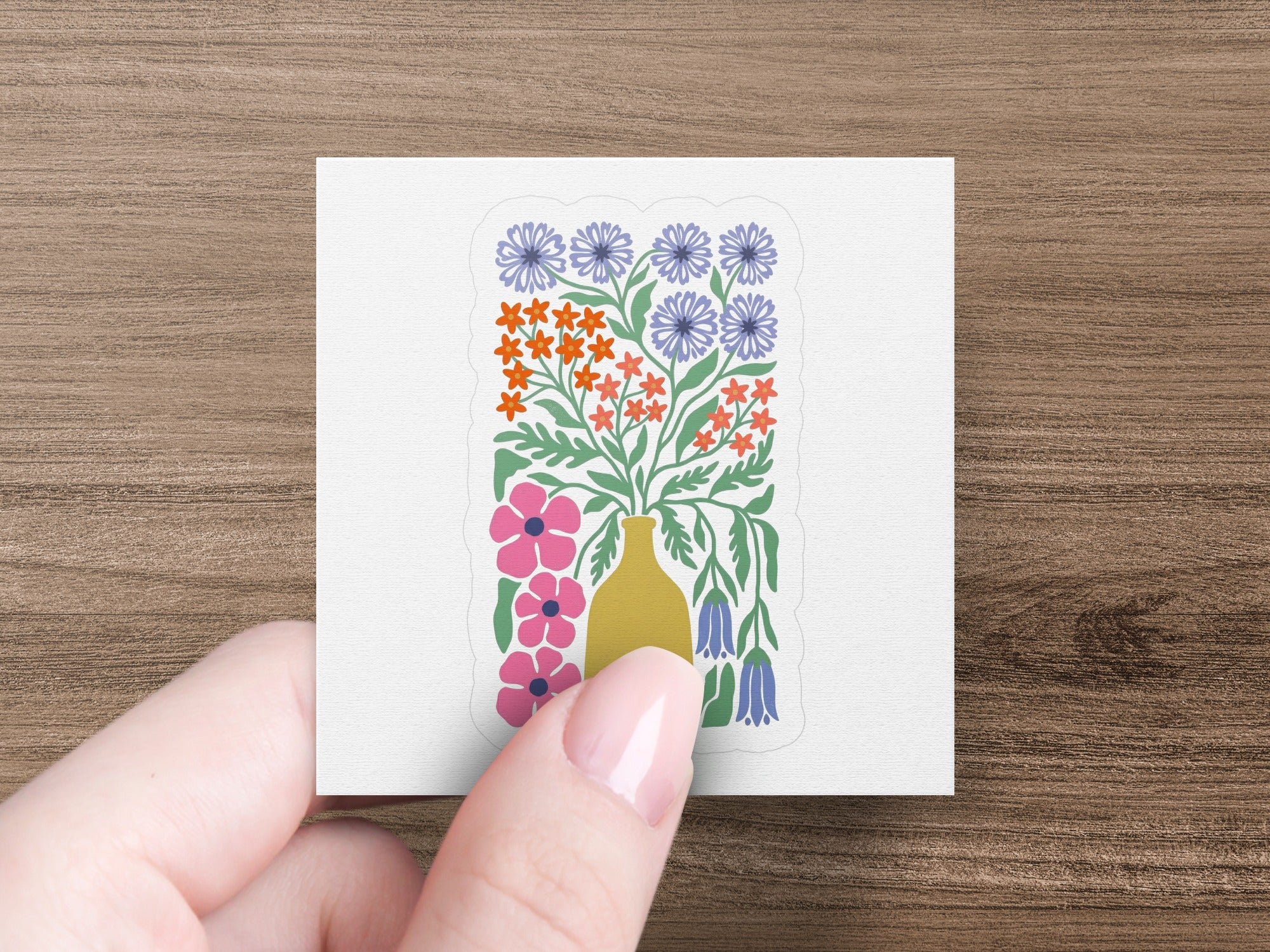 Floral illustration with pink flowers, blue and orange blossoms, and yellow bells in a vase.