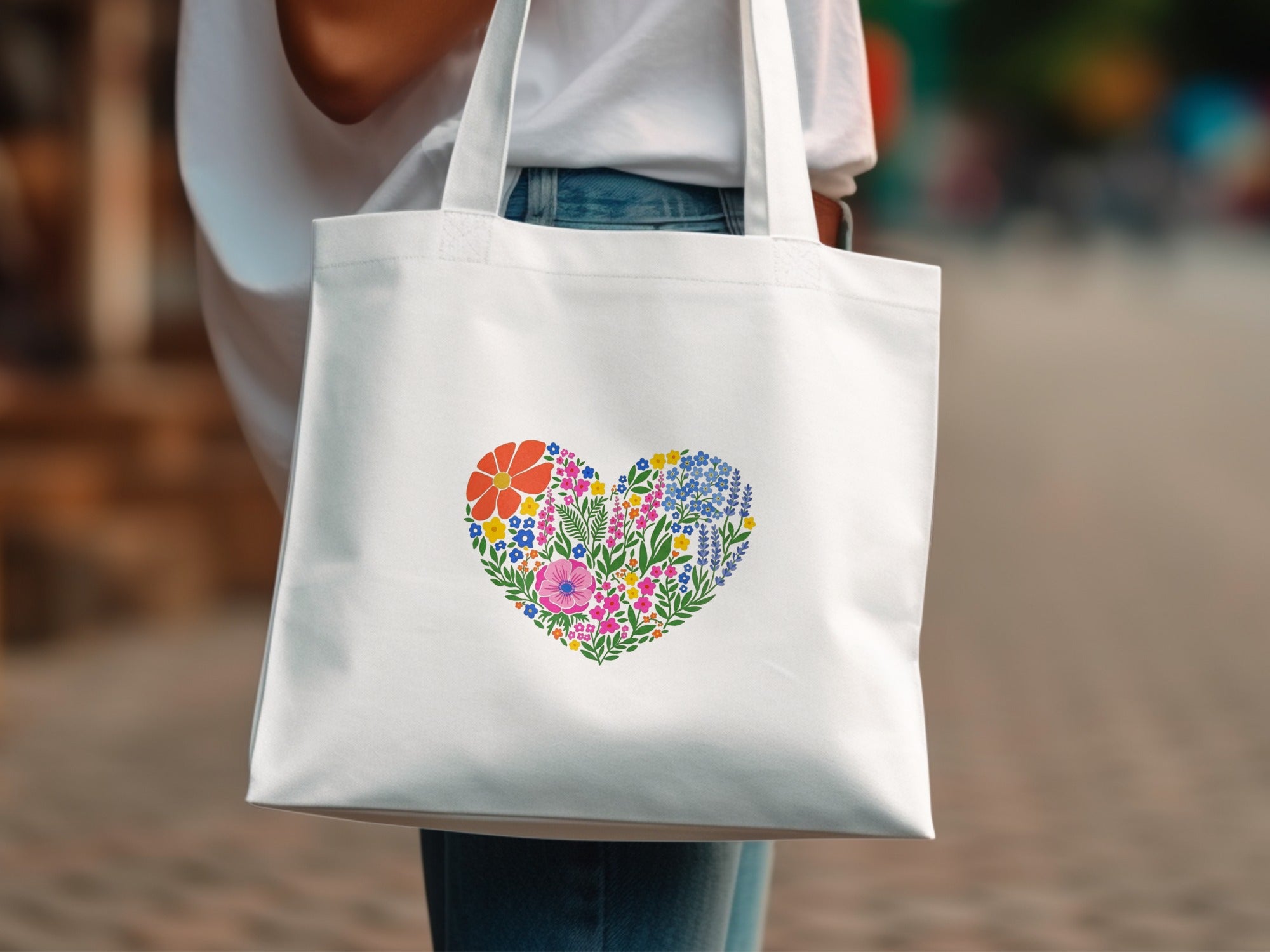 White tote bag with a colorful floral heart design.