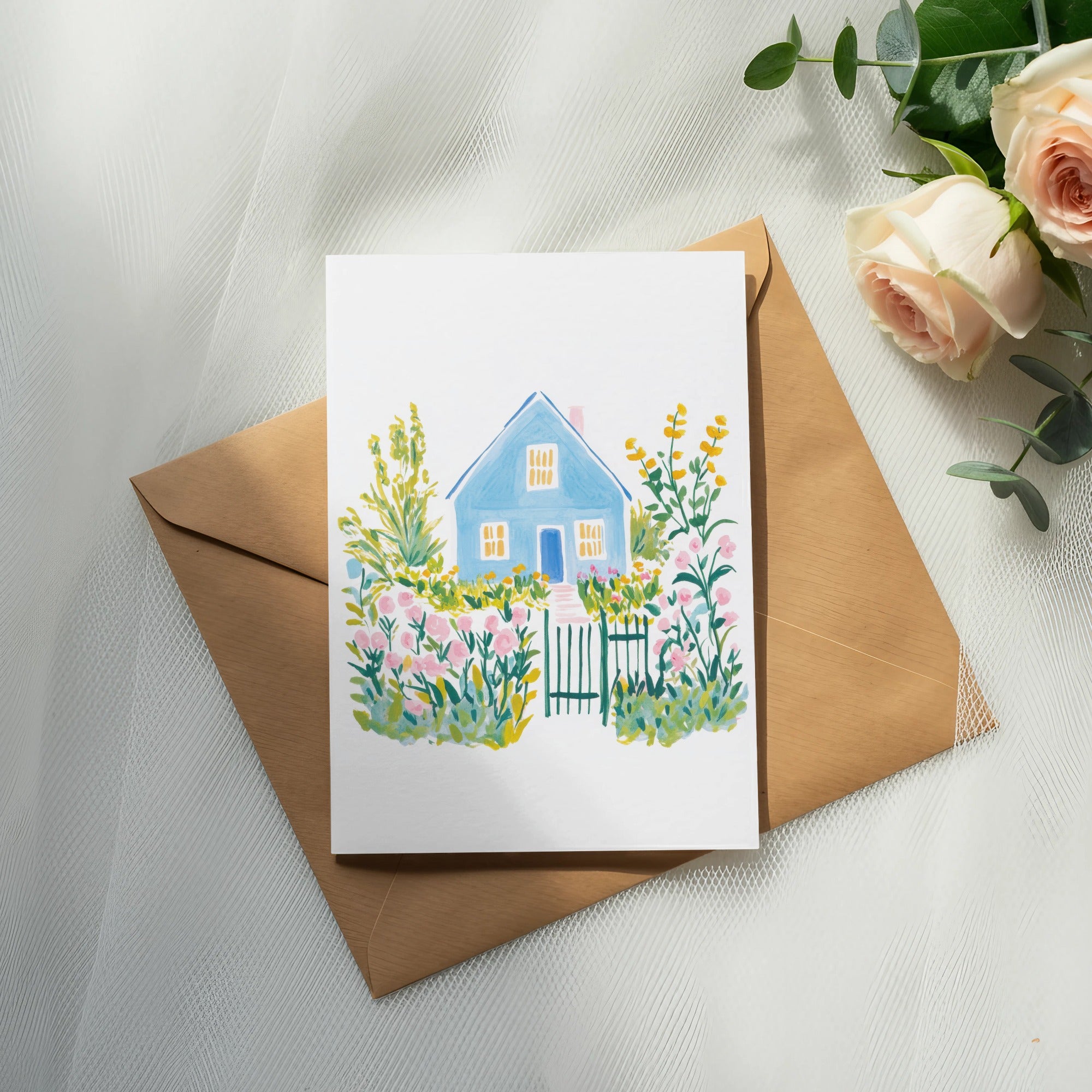 Watercolor painting of a blue house with pink flowers and green gate on a brown envelope.
