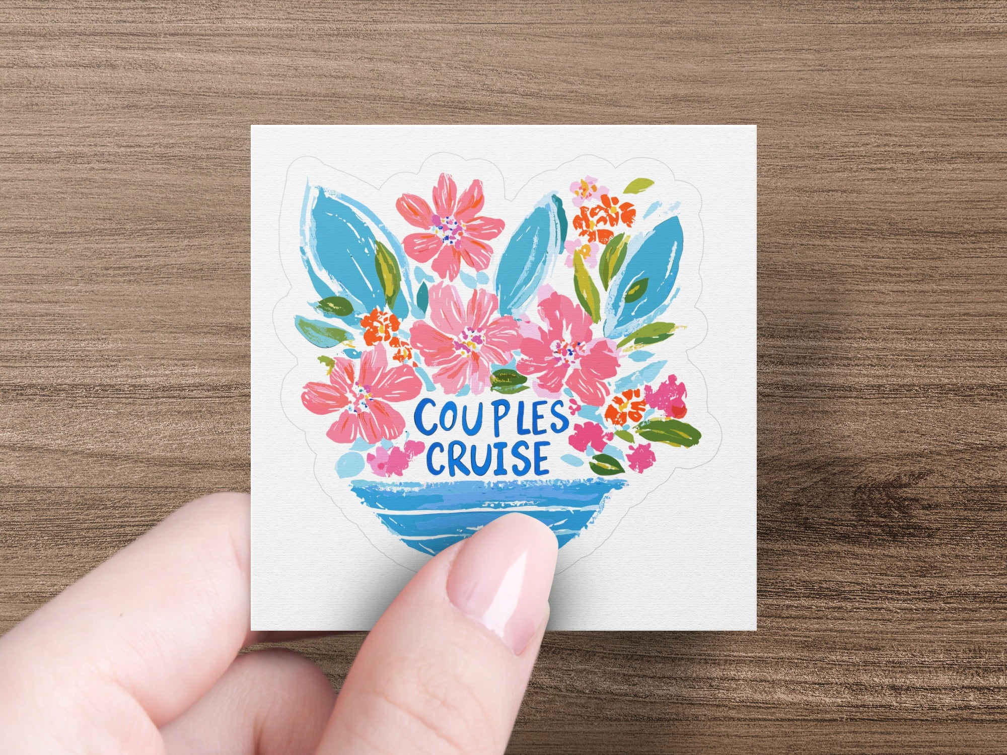 Hand holding "Couples Cruise" sticker with floral bouquet.