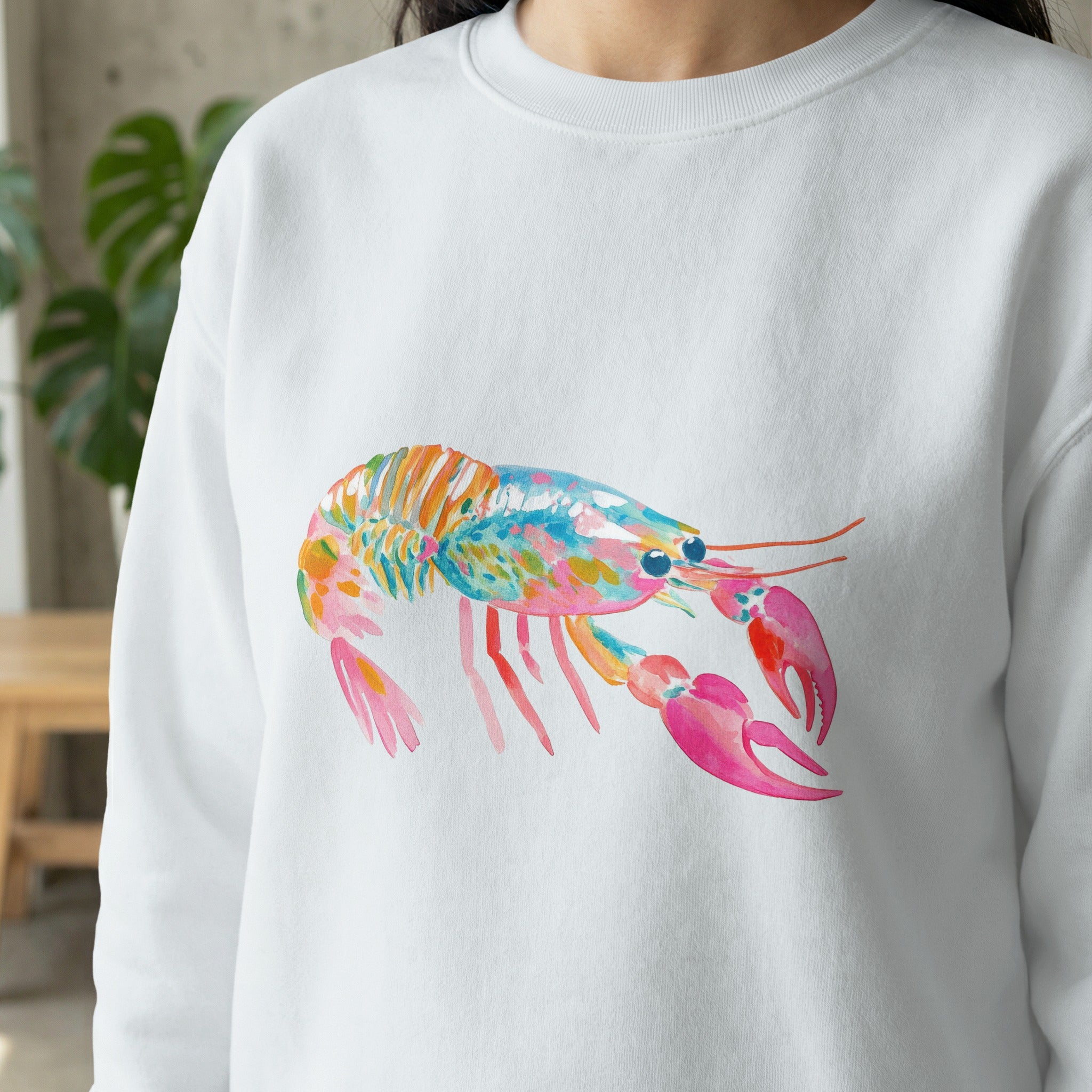 White sweatshirt with colorful watercolor lobster graphic.