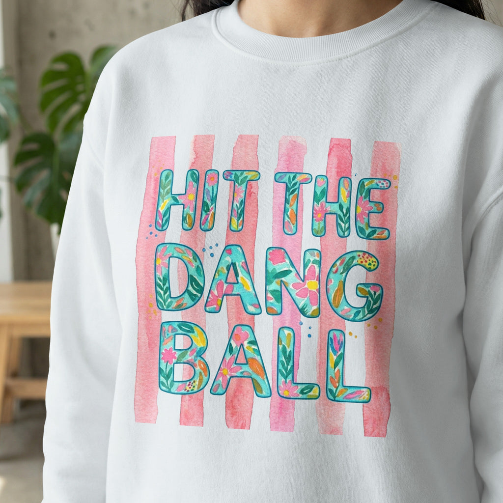 White sweatshirt with "Hit the dang ball" in floral watercolor letters.