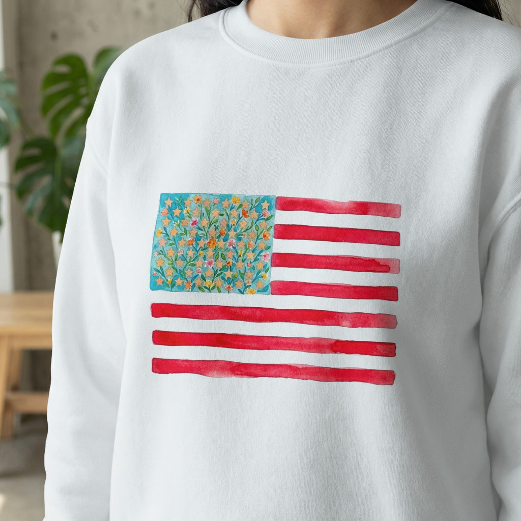 White sweatshirt with a watercolor American flag featuring floral details.