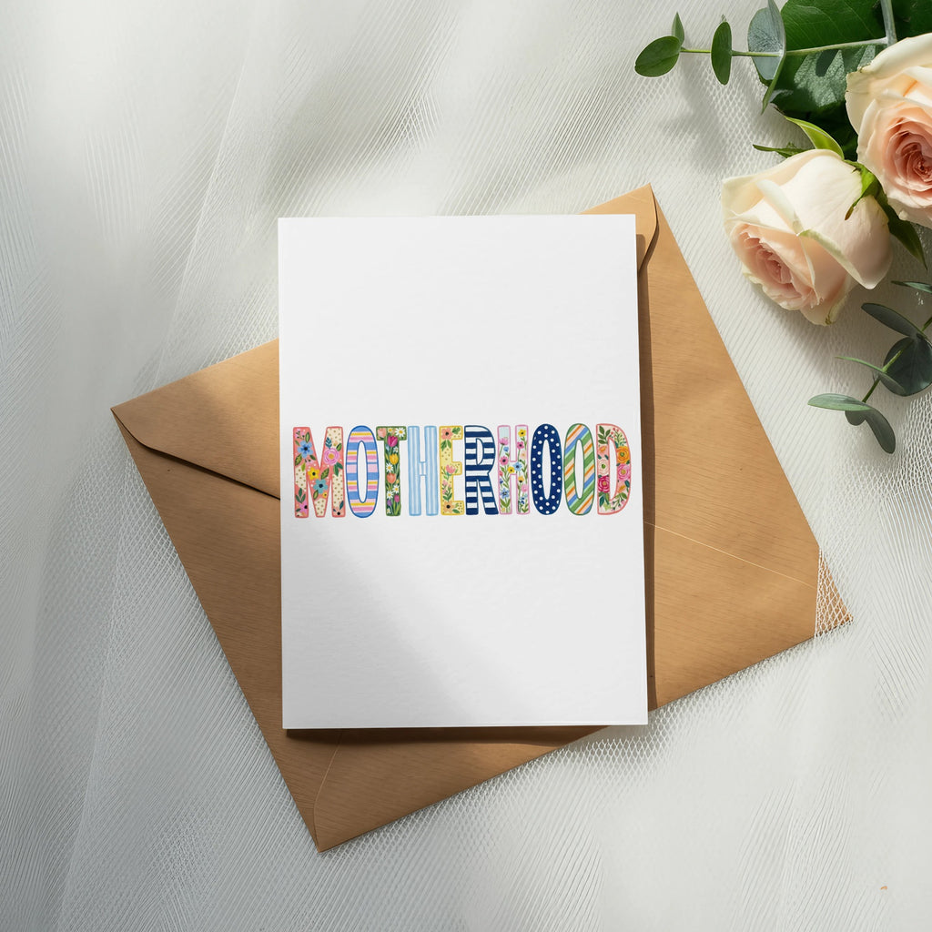 Card with "MOTHERHOOD" in colorful, patterned letters on envelope.