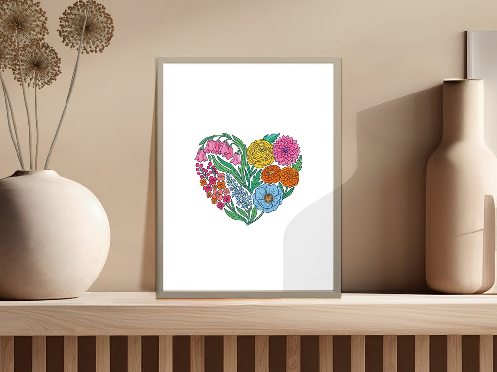 Floral heart artwork with pink, orange, yellow, and blue flowers on a shelf.