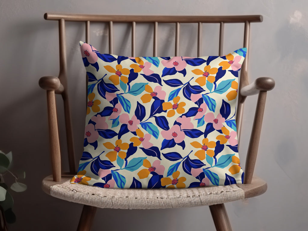 Cream pillow with a vibrant floral pattern in pink, orange, blue, and green.