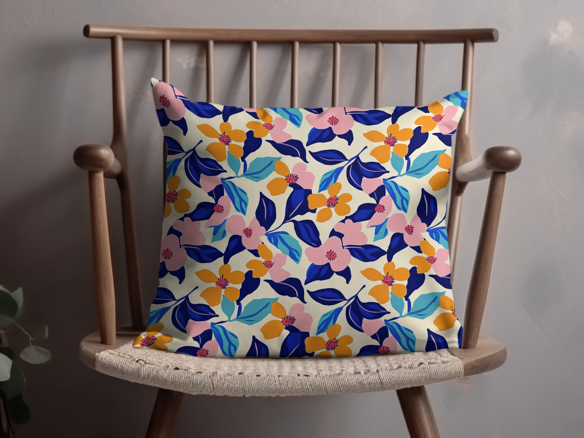 Cream pillow with a vibrant floral pattern in pink, orange, blue, and green.