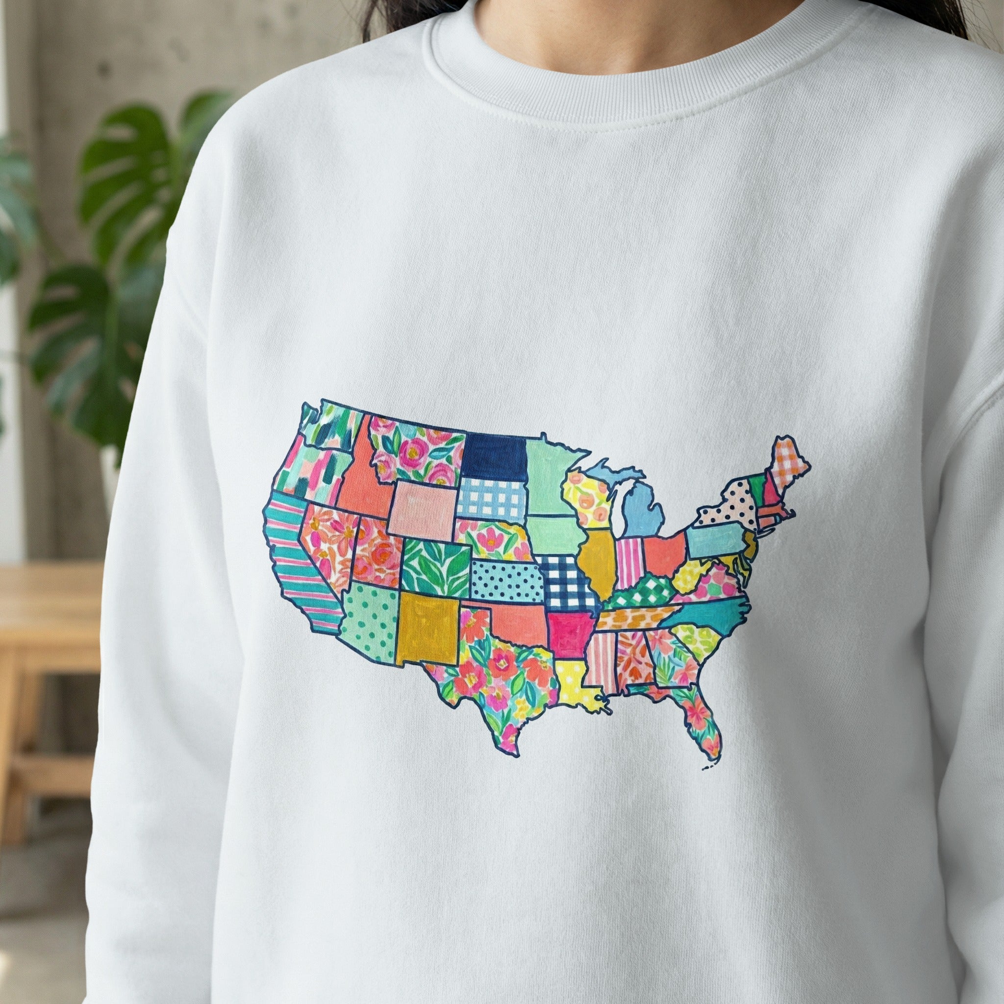 White sweatshirt with a colorful patchwork map of the United States.