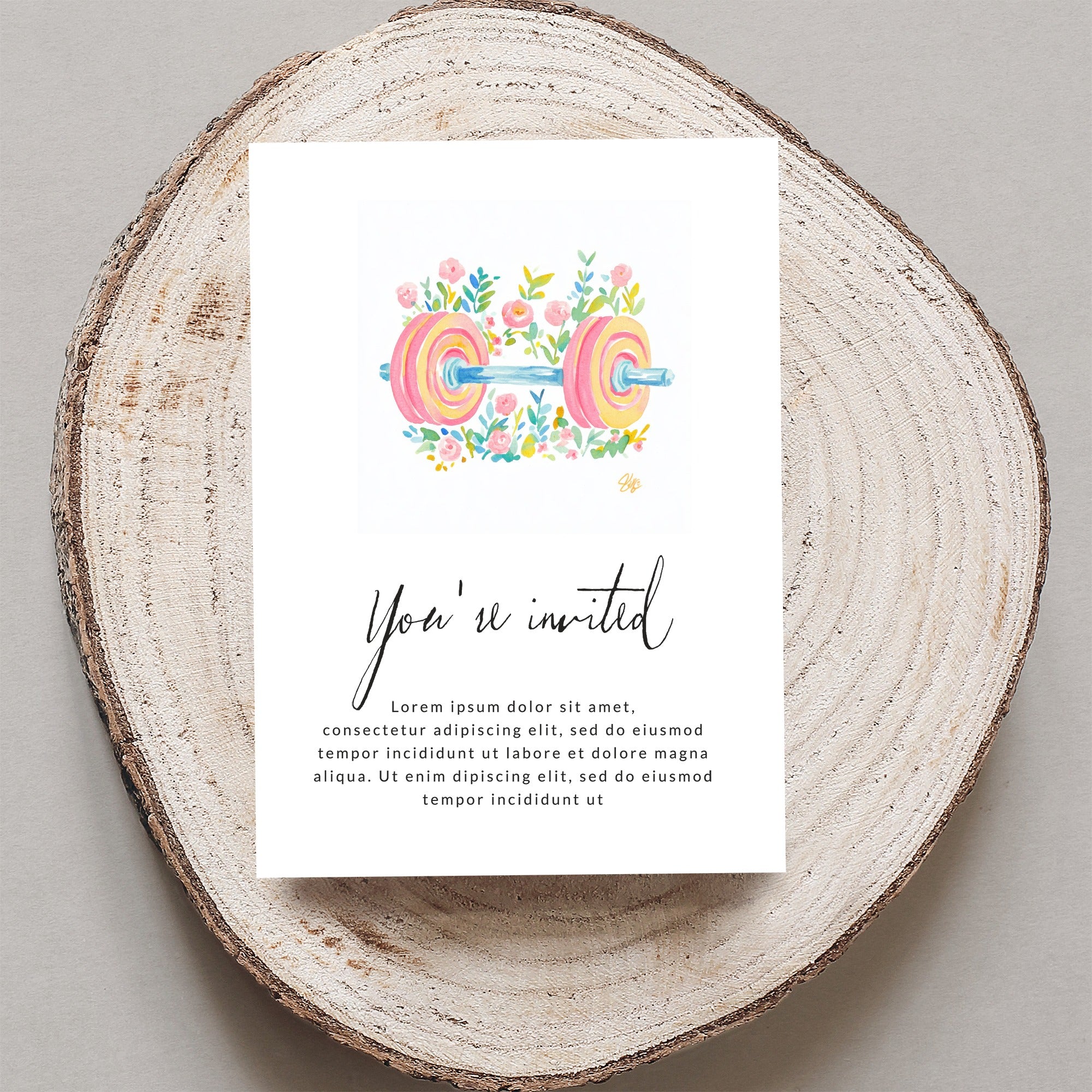 Watercolor barbell with floral accents on an invitation card.