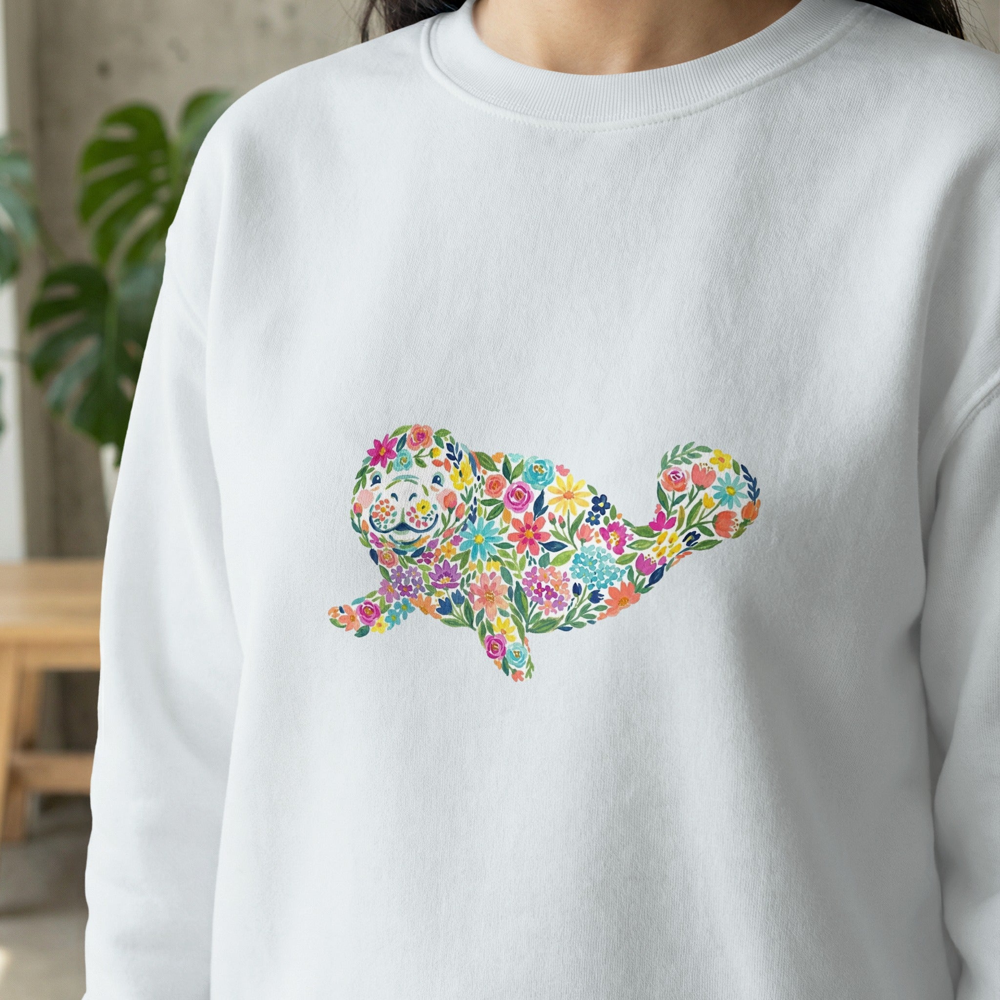 White sweatshirt with a colorful floral seal graphic.