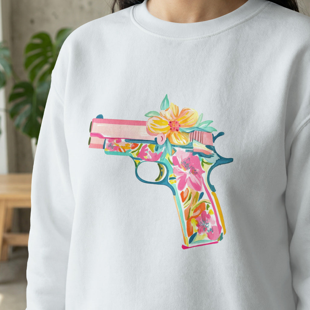 White sweatshirt with colorful floral pistol graphic.
