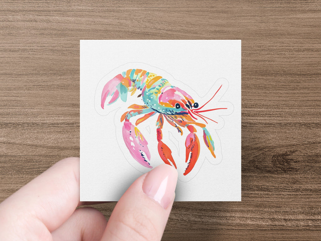Colorful lobster sticker on textured white paper held by a hand.