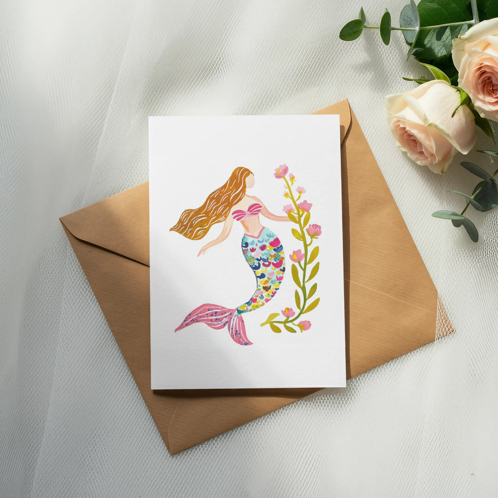 Watercolor mermaid illustration on card with pink flowers and greenery.
