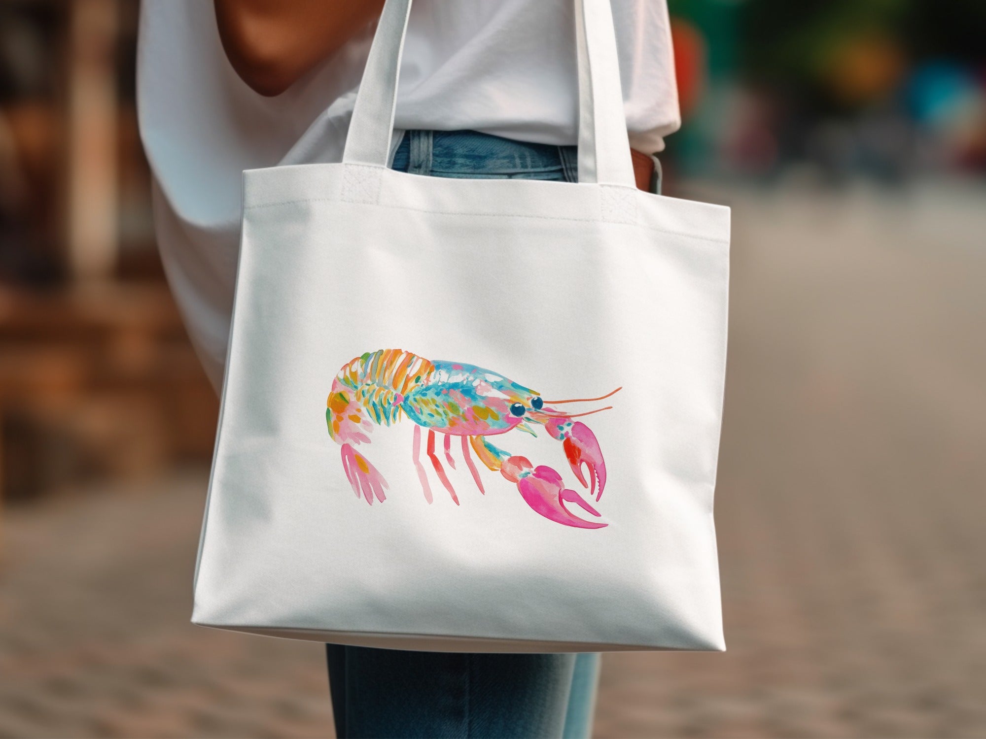 White canvas tote bag with colorful watercolor lobster graphic.