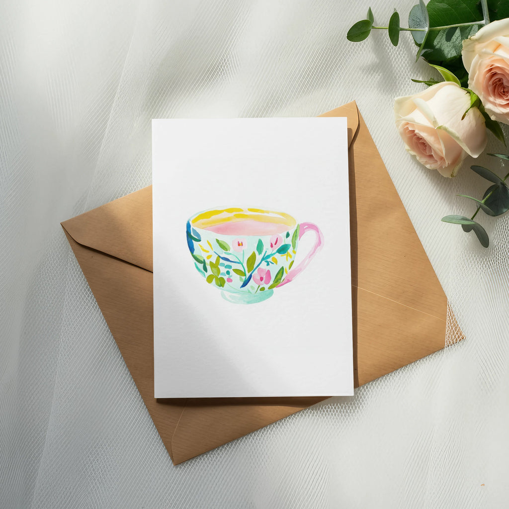 Watercolor teacup illustration on a card with an envelope and roses.