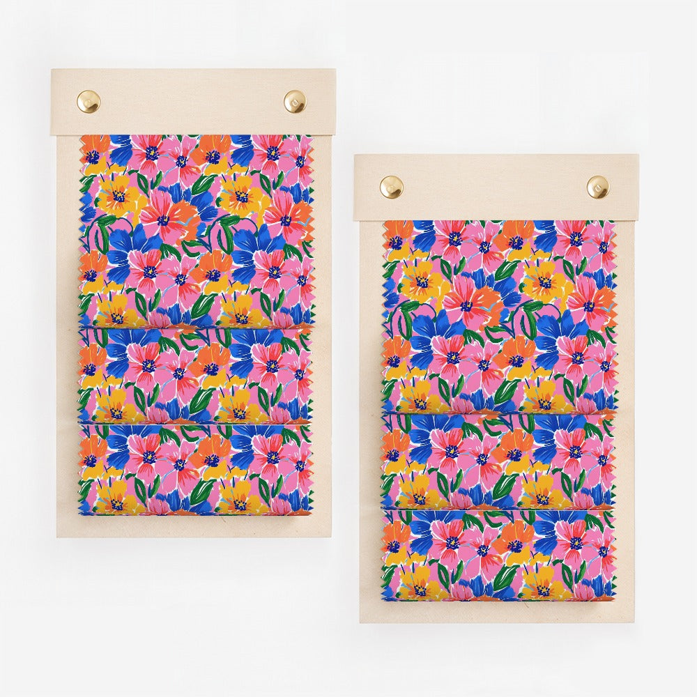 Two fabric swatches with colorful floral patterns in pink, blue, yellow, and green.