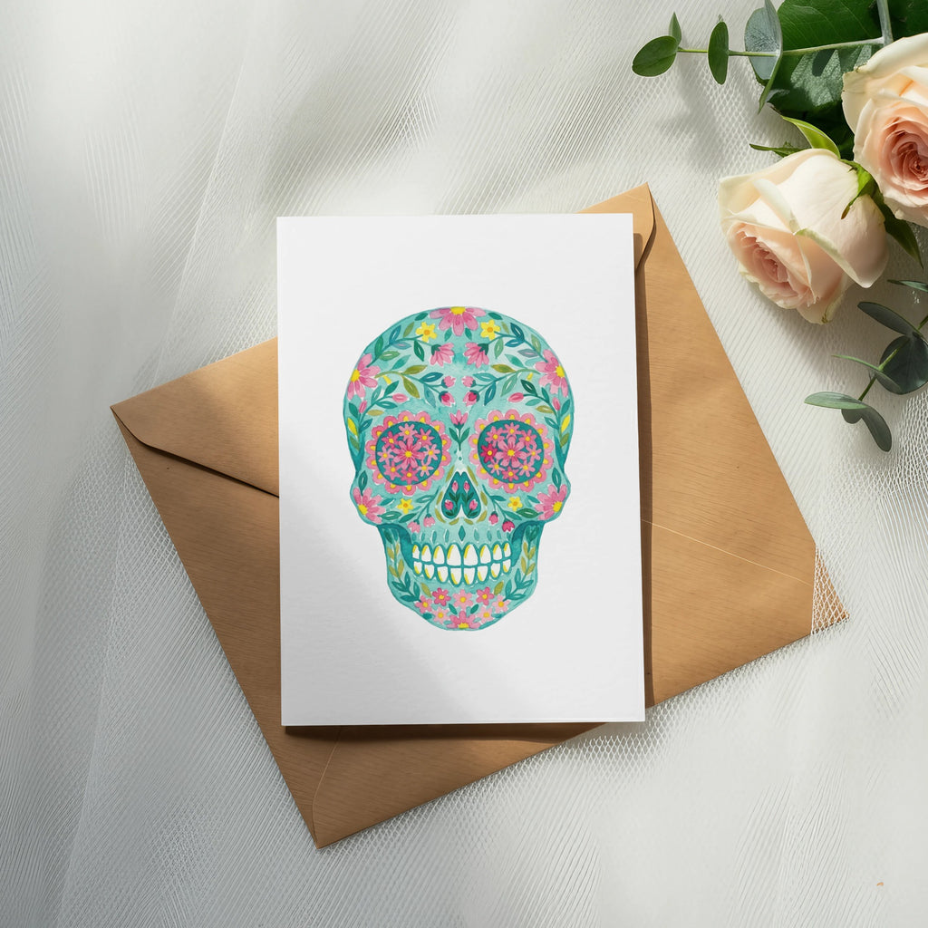 Floral sugar skull art on a white card with a brown envelope.