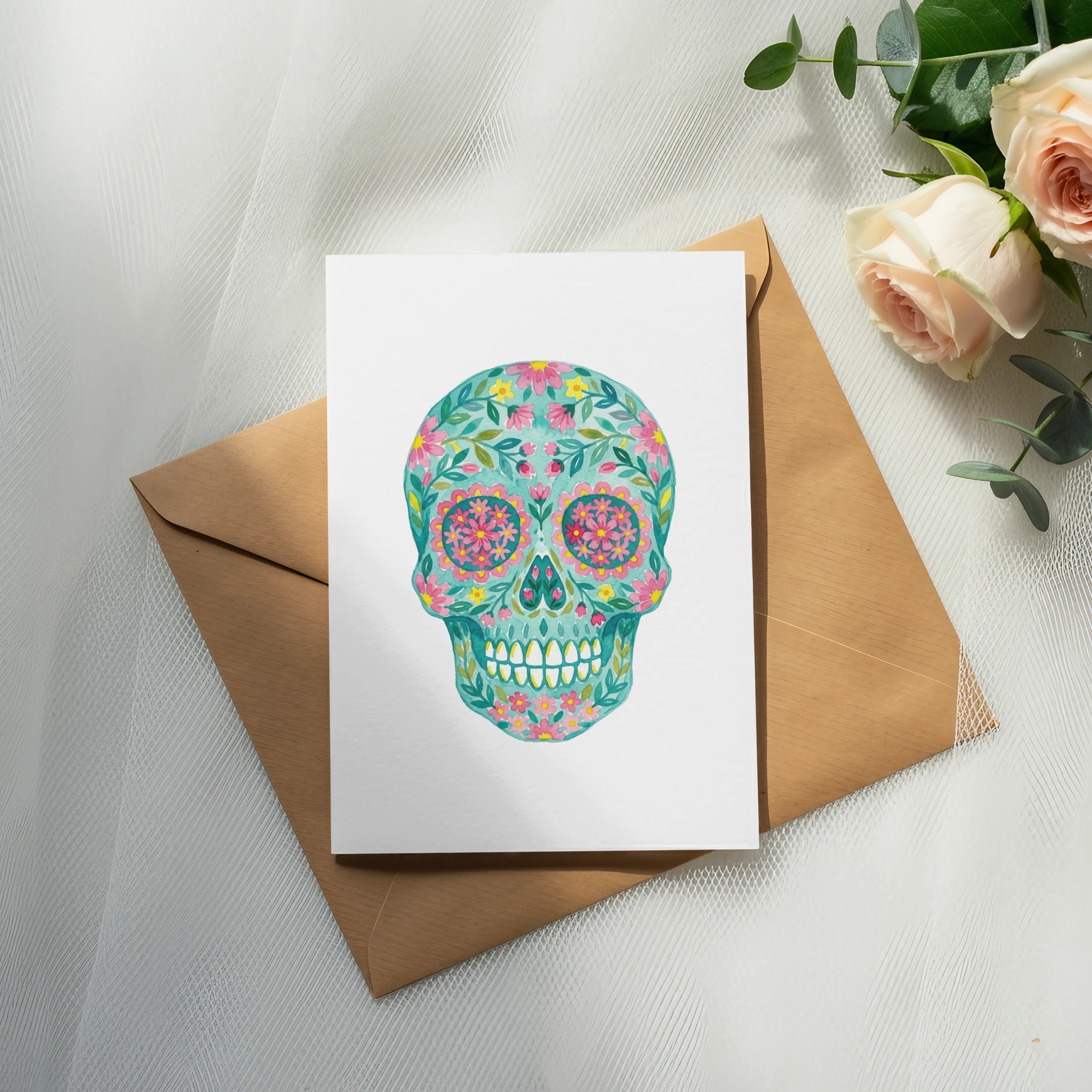Floral sugar skull art on a white card with a brown envelope.