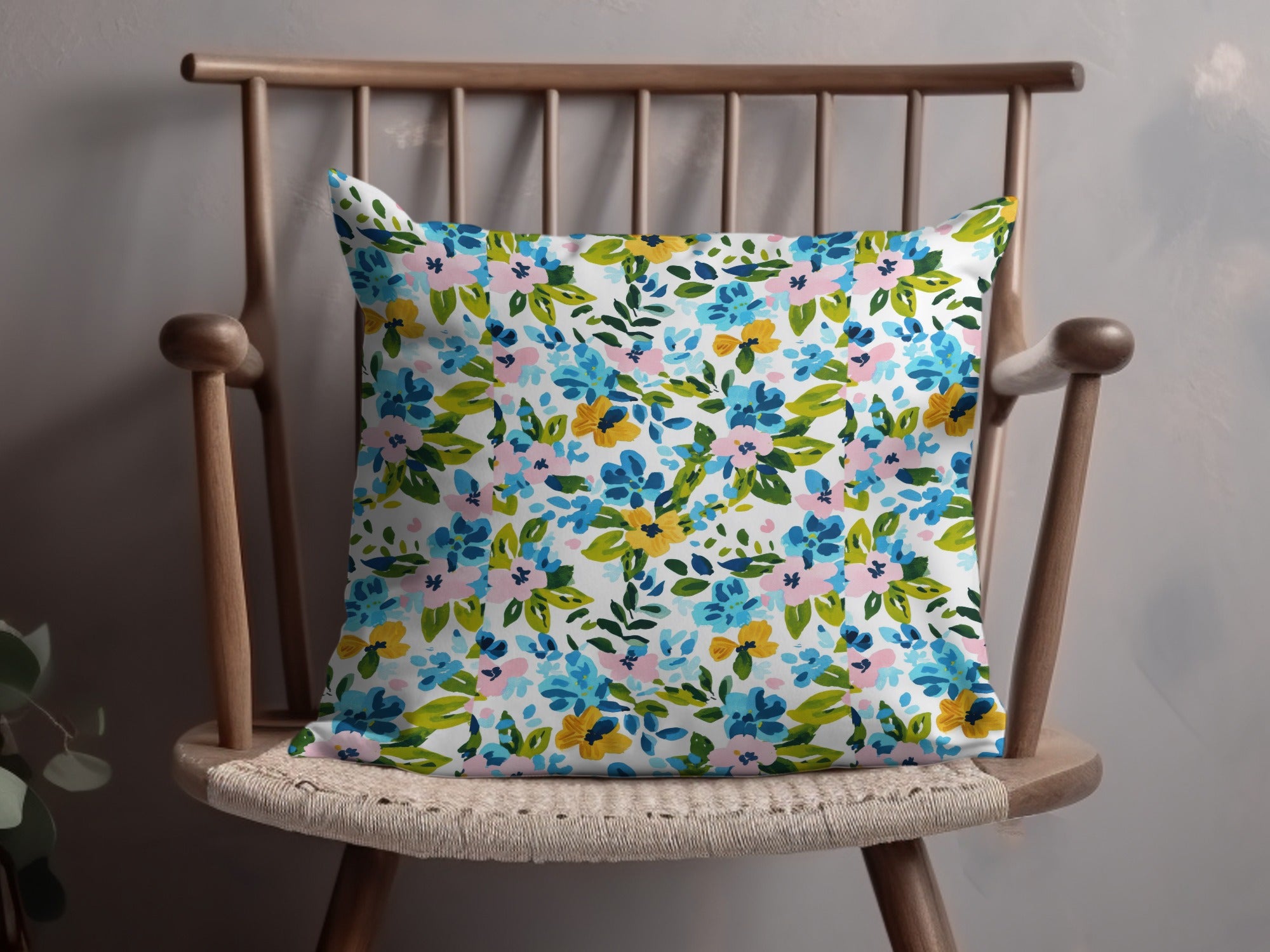 Floral pattern pillow on a wooden chair.
