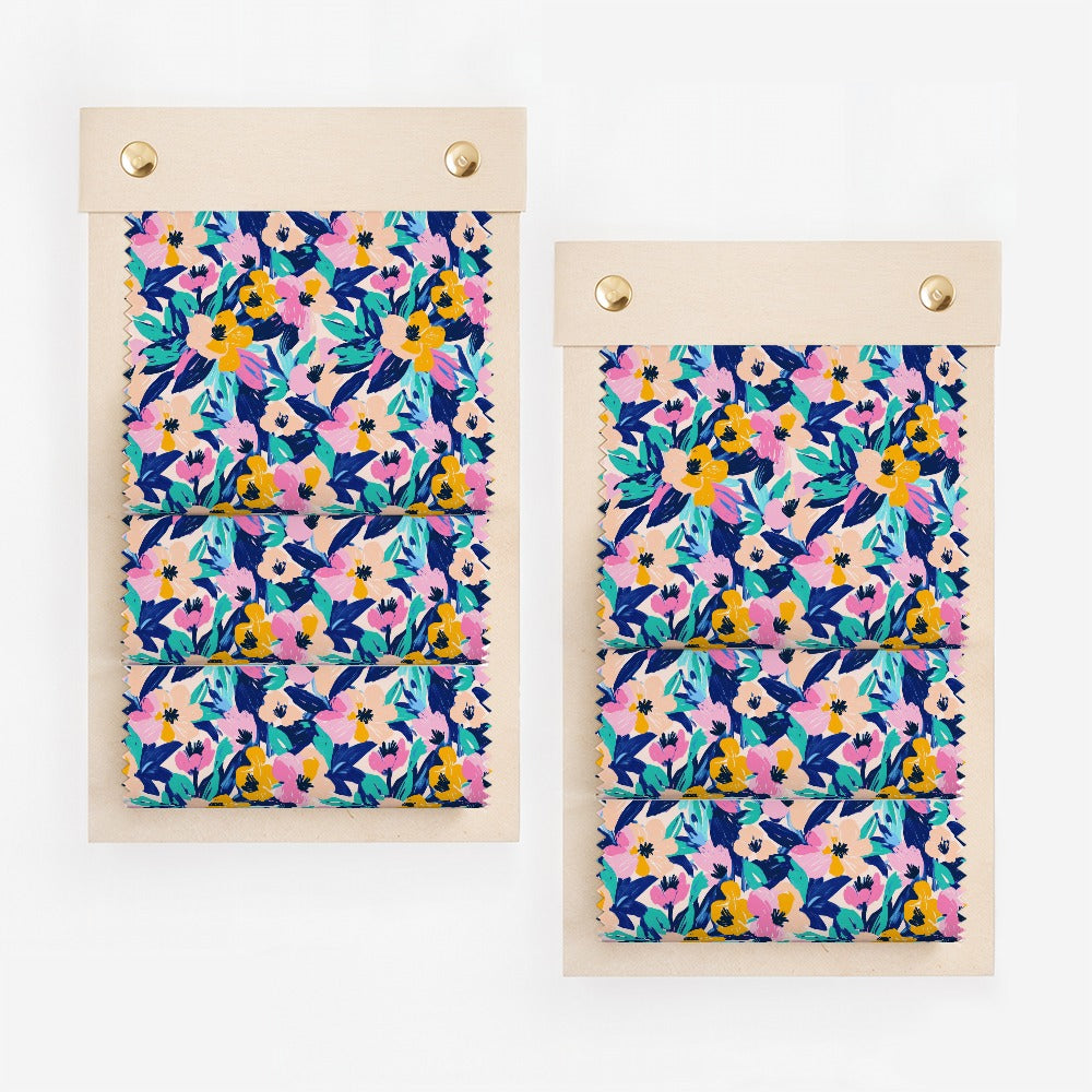 Two fabric swatches with a vibrant floral pattern in blue, pink, and yellow.