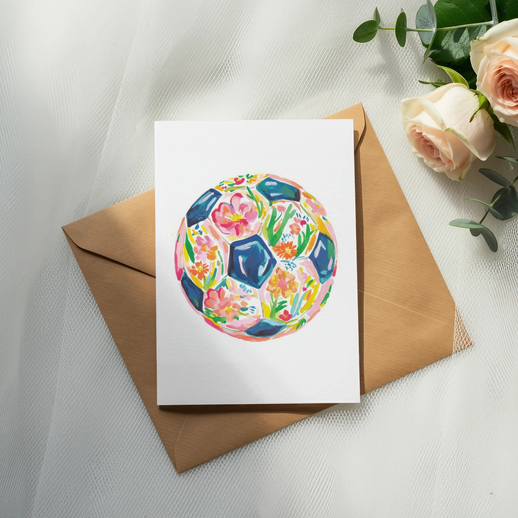 Watercolor soccer ball design on a card with envelope and roses.