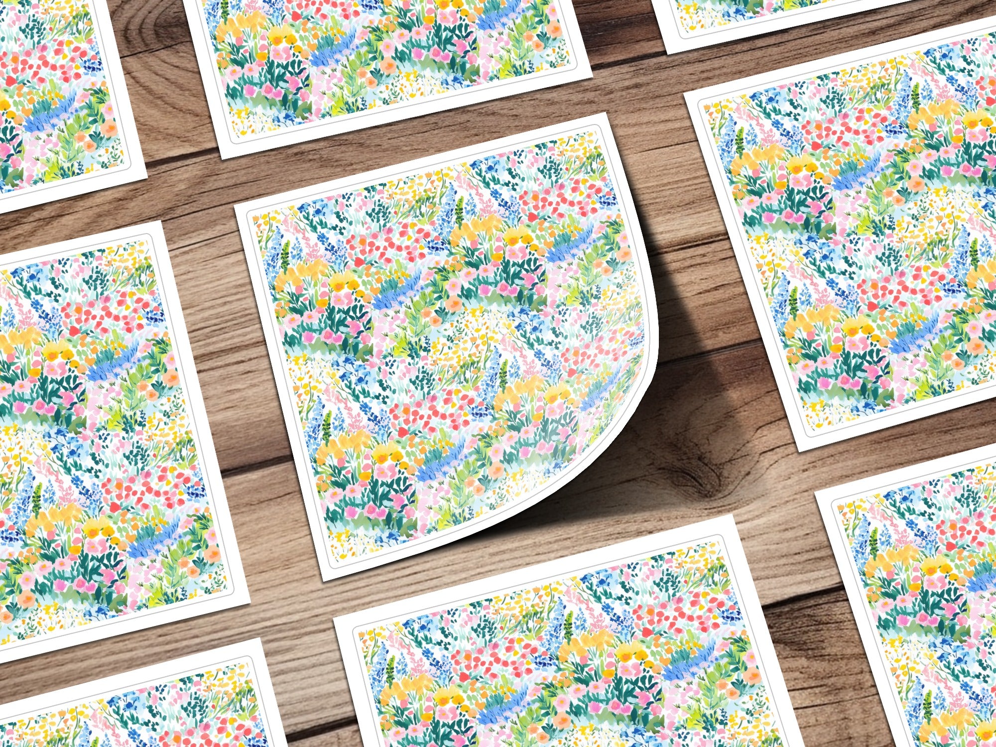 Floral pattern stationery cards scattered on a wooden surface.