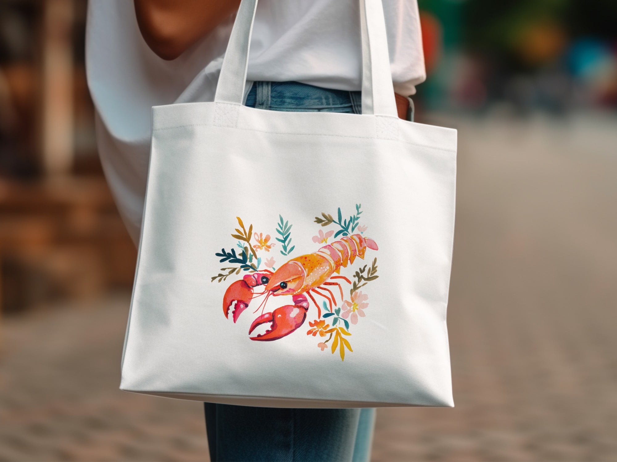 White canvas tote bag with lobster and floral watercolor graphic.