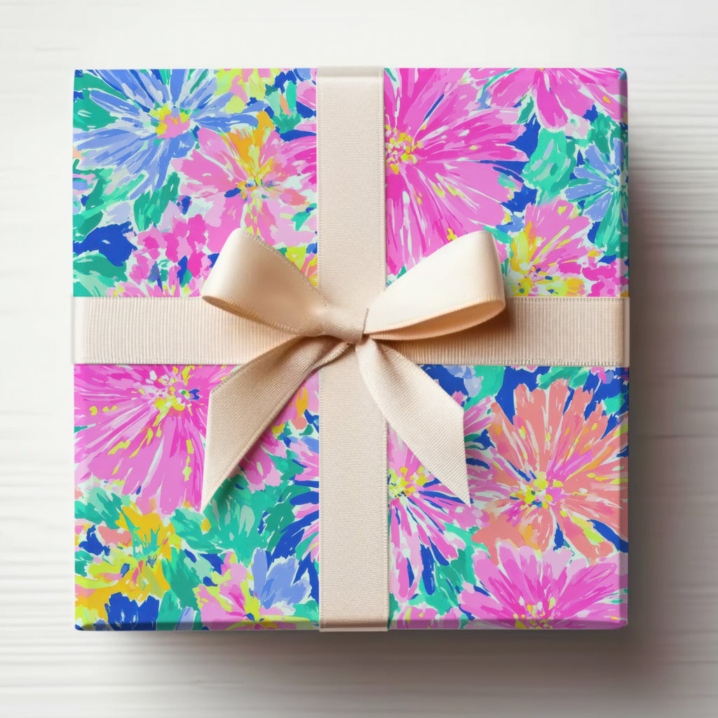 Gift box wrapped in colorful floral paper with a light beige ribbon.