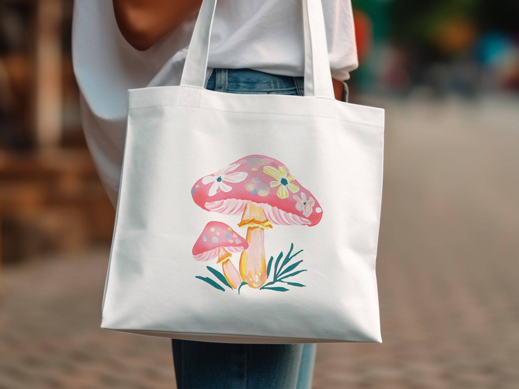 White tote bag with watercolor-style pink mushrooms and green leaves design.