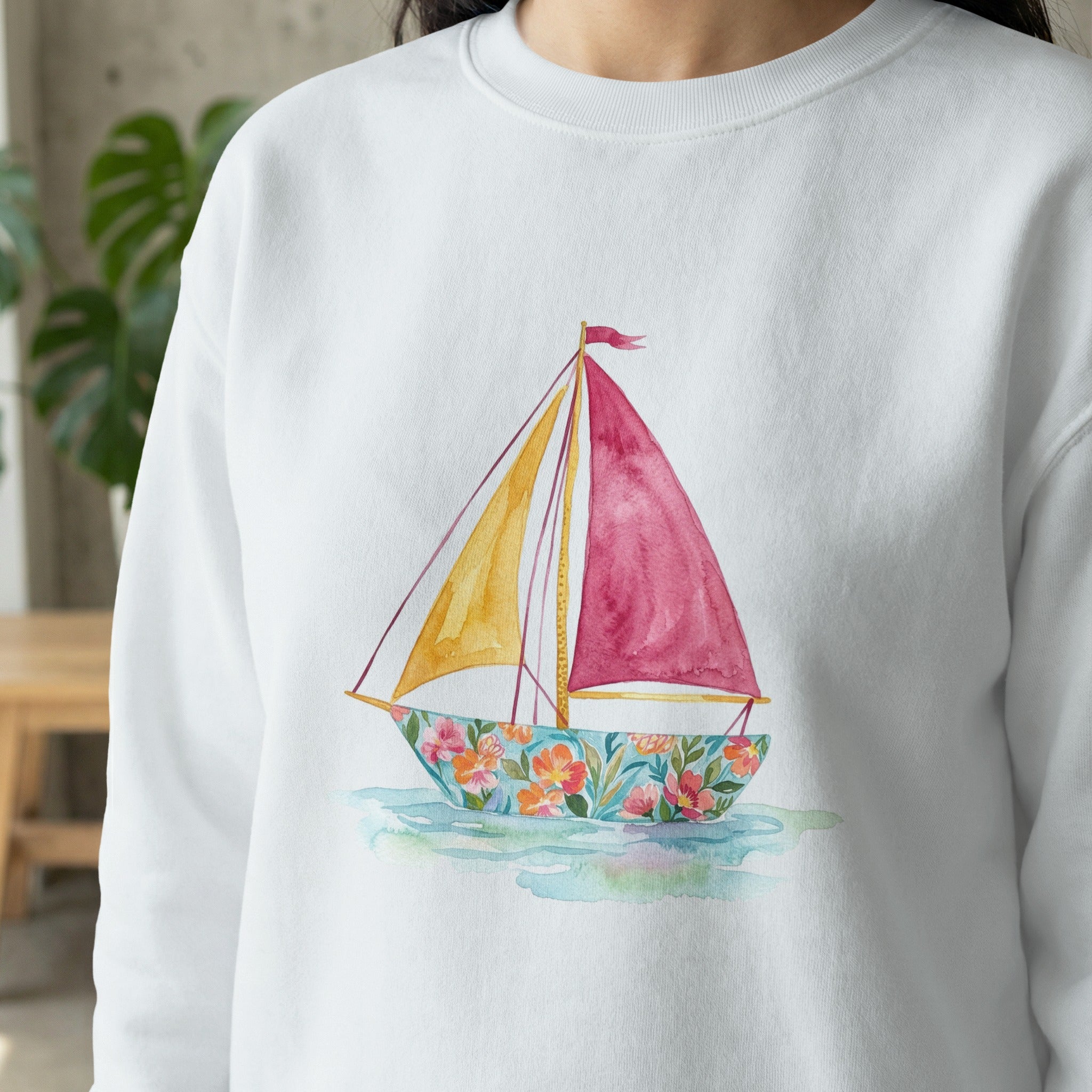 White sweatshirt with a colorful sailboat watercolor design.