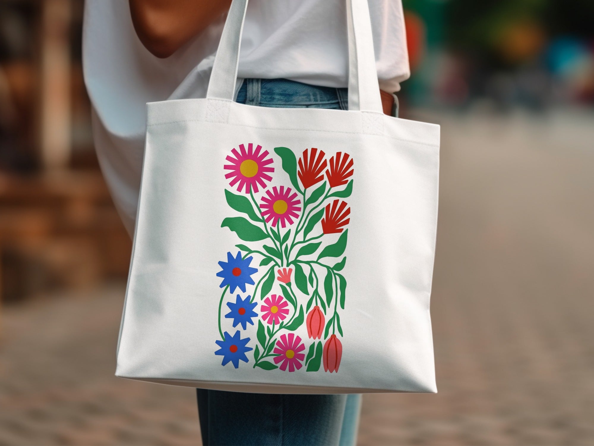White tote bag with colorful floral folk art design.