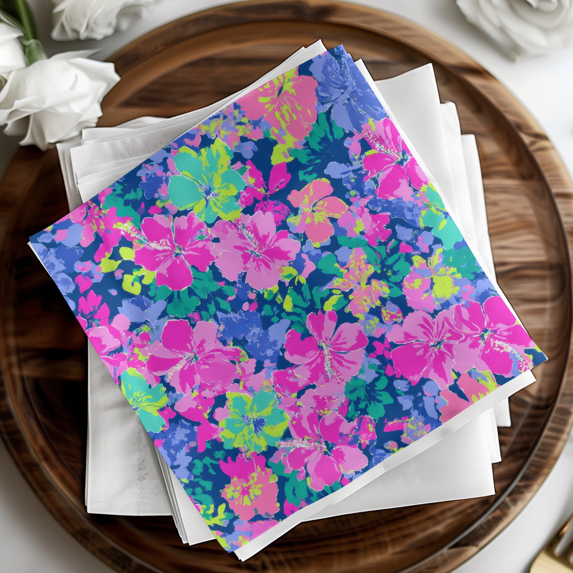 Colorful hibiscus floral pattern napkins on white cloth.