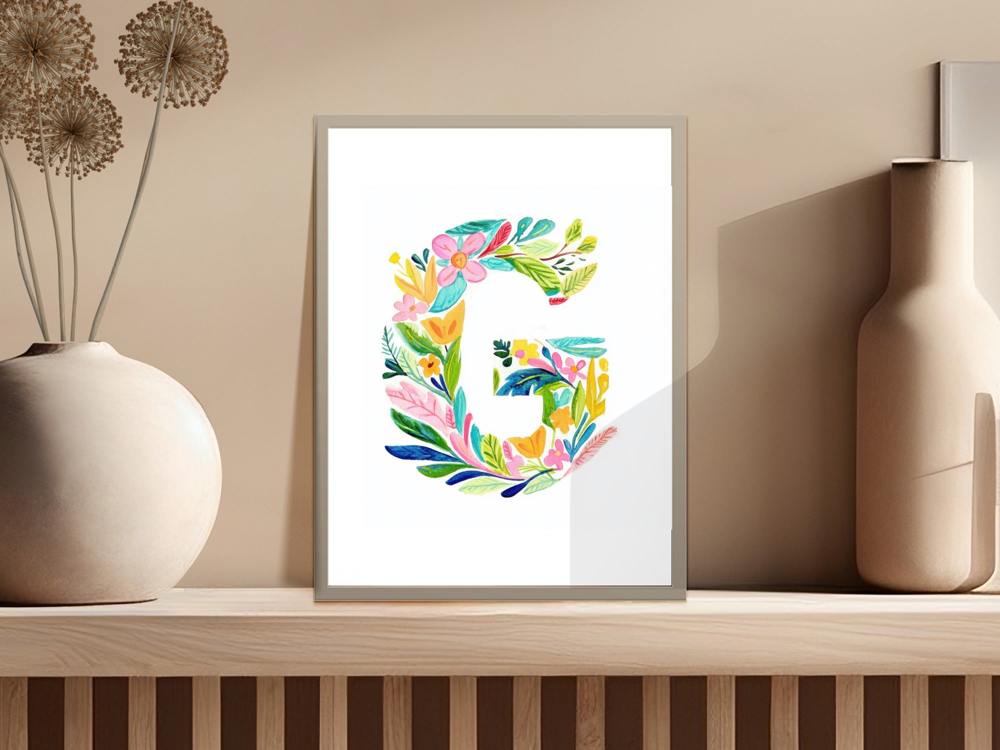 Watercolor letter G with colorful flowers and leaves.
