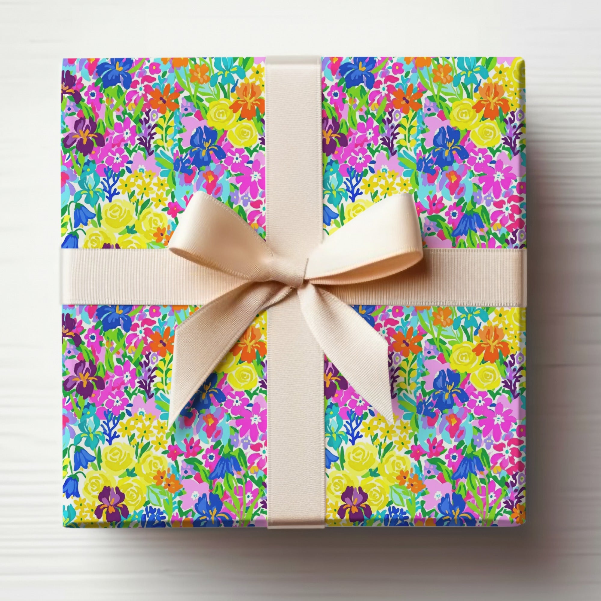 Gift-wrapped box with colorful floral pattern and cream ribbon.
