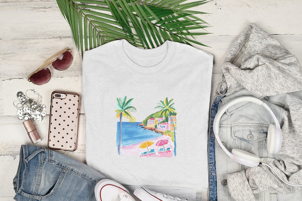 White t-shirt with a tropical beach scene illustration.