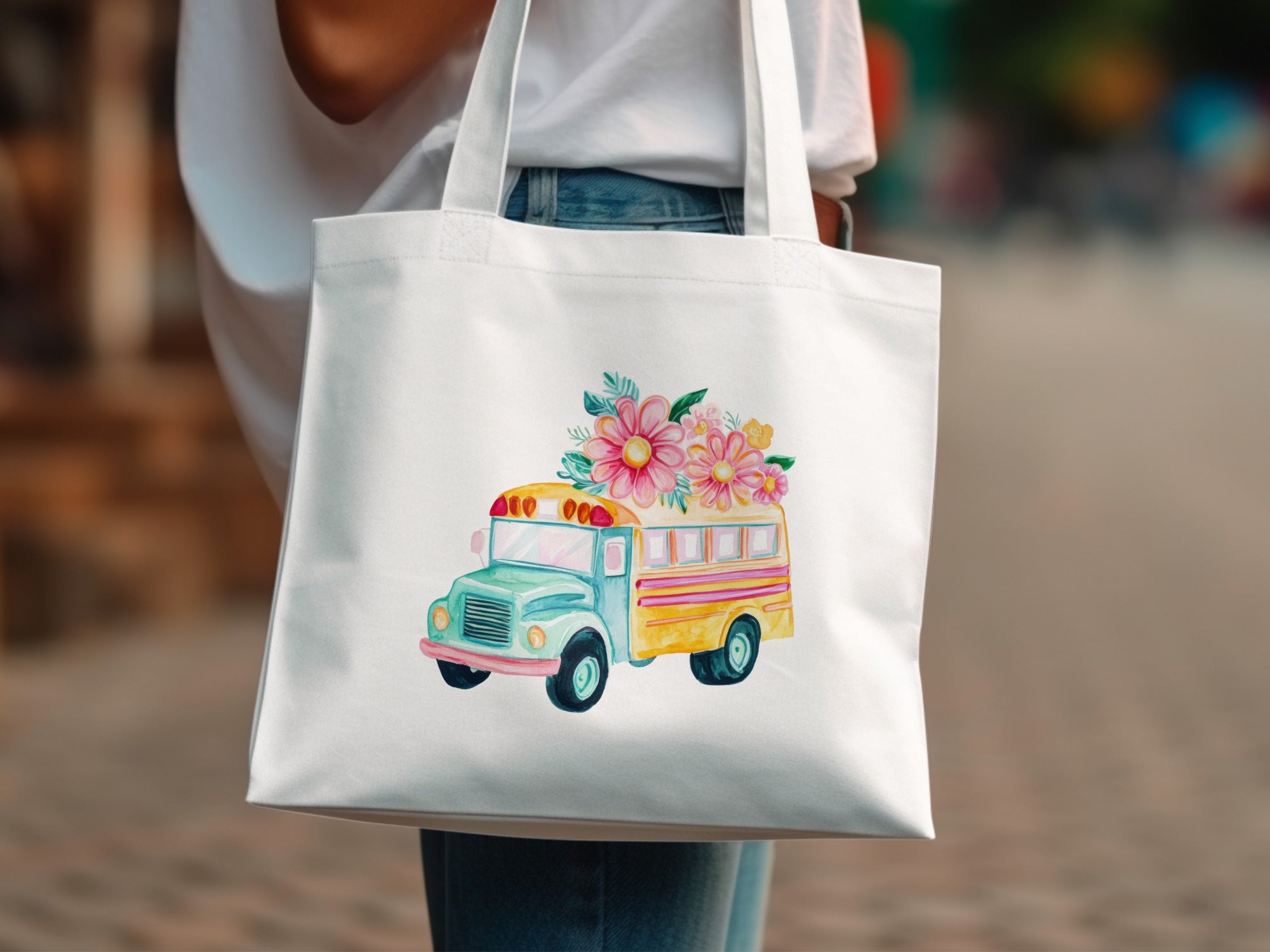 White tote bag with watercolor illustration of a school bus adorned with flowers.